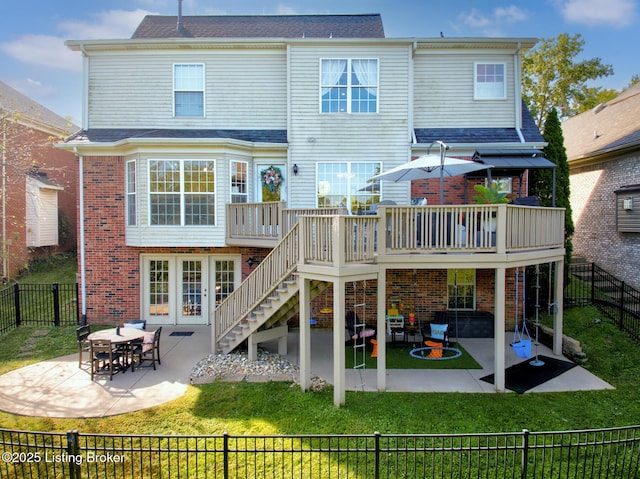 rear view of property featuring a yard, a patio, brick siding, and a fenced backyard