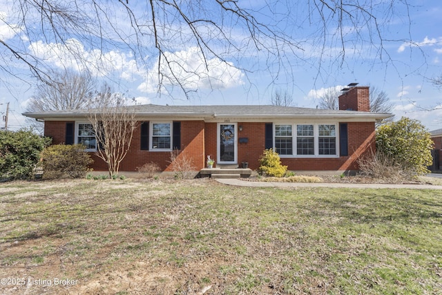 ranch-style house with brick siding, a chimney, and a front lawn