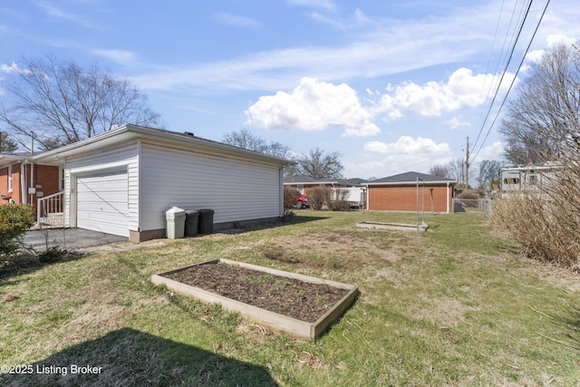 view of yard with driveway, a vegetable garden, and fence