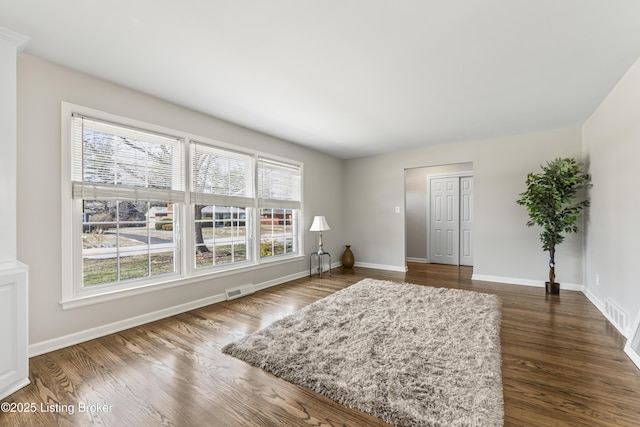 sitting room featuring visible vents, dark wood-type flooring, and baseboards