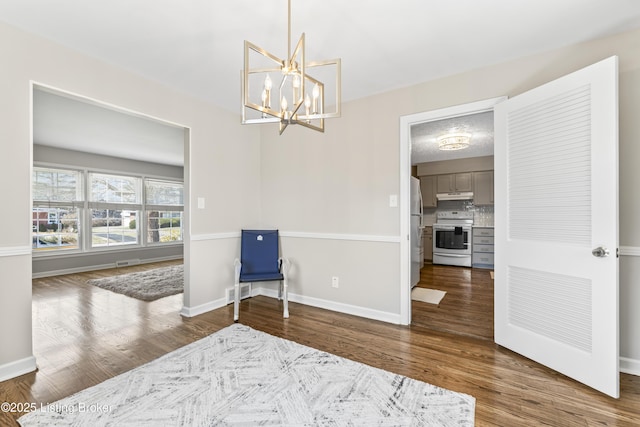 sitting room featuring visible vents, baseboards, wood finished floors, and a chandelier