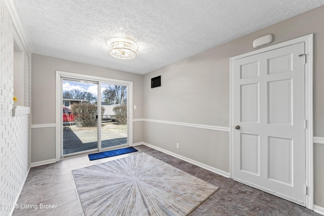 empty room featuring baseboards and a textured ceiling