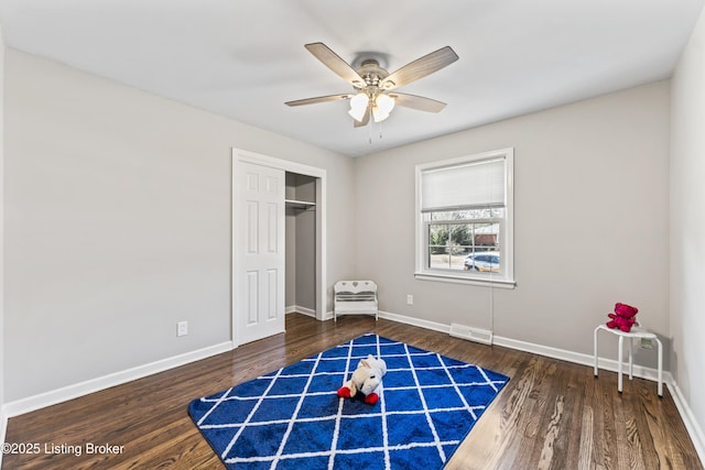 unfurnished bedroom featuring visible vents, ceiling fan, baseboards, wood finished floors, and a closet