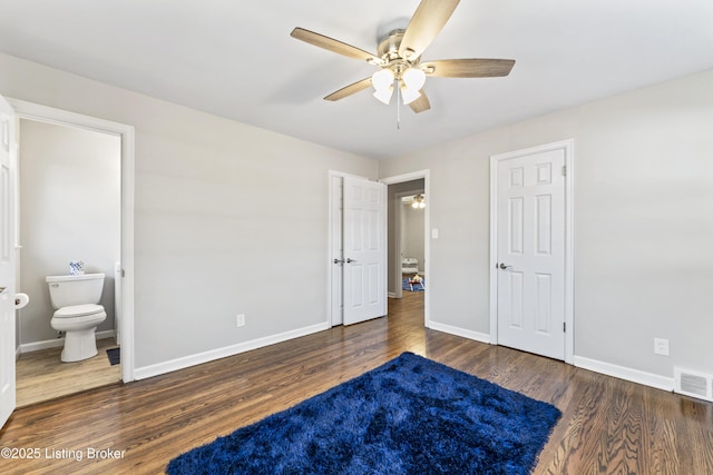 bedroom with visible vents, a ceiling fan, ensuite bath, wood finished floors, and baseboards