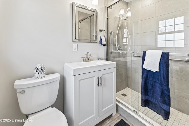 bathroom featuring vanity, toilet, and a stall shower