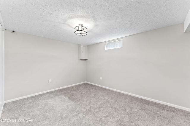 empty room with visible vents, carpet floors, a textured ceiling, and baseboards