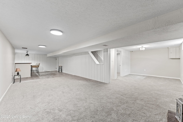 finished basement featuring baseboards, carpet floors, and a textured ceiling