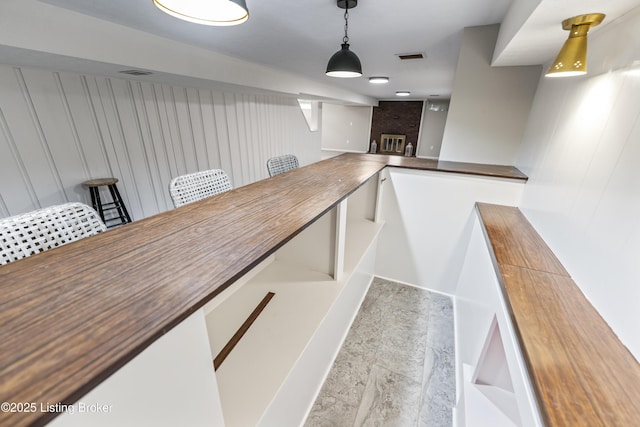 interior space with wooden walls, a fireplace, and visible vents