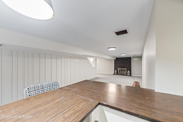 interior space featuring a brick fireplace, carpet, and open floor plan