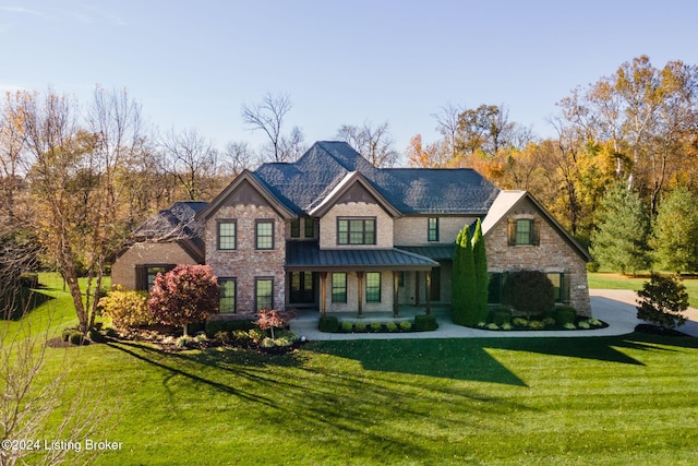 view of front of house with a standing seam roof, a front lawn, a porch, and metal roof