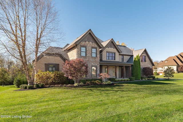 view of front facade with stone siding and a front lawn