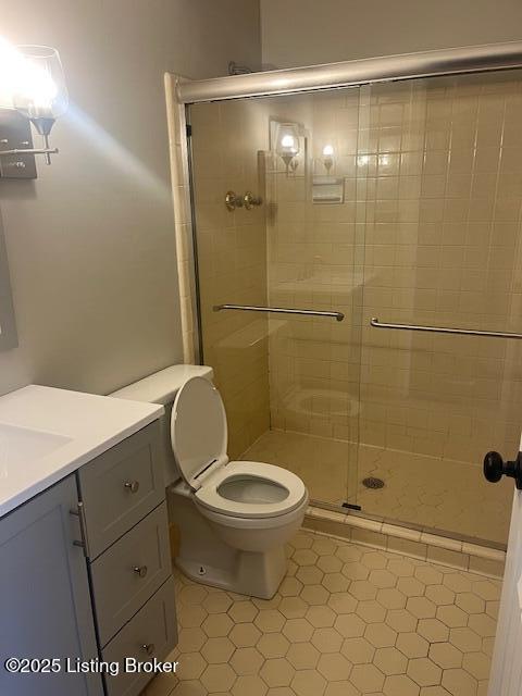 full bathroom with toilet, a stall shower, and vanity