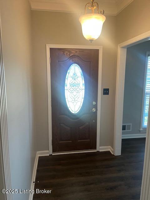 entryway with baseboards, visible vents, dark wood-style flooring, and ornamental molding