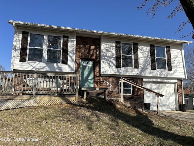 raised ranch with an attached garage, brick siding, and driveway