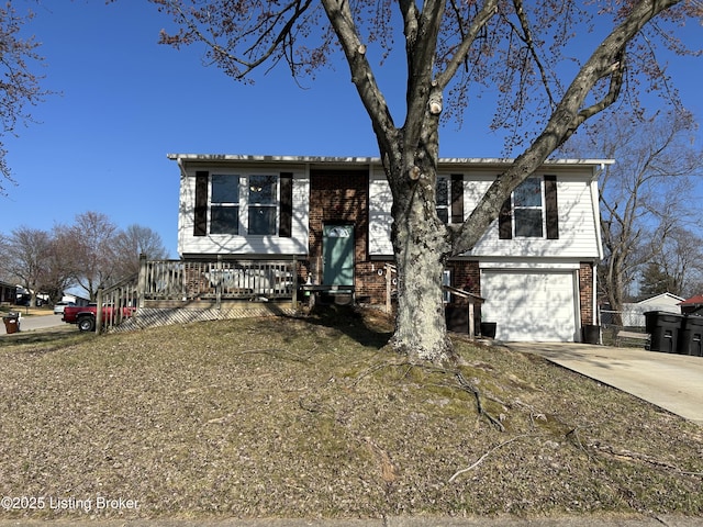 raised ranch with brick siding, concrete driveway, and an attached garage