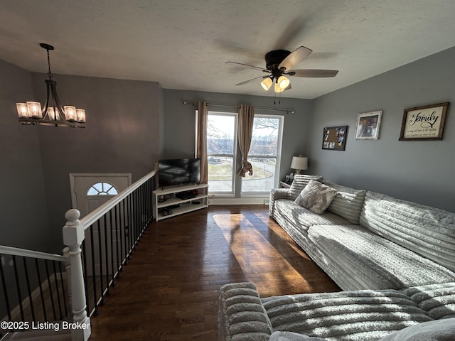 living area featuring ceiling fan with notable chandelier, a textured ceiling, and wood finished floors