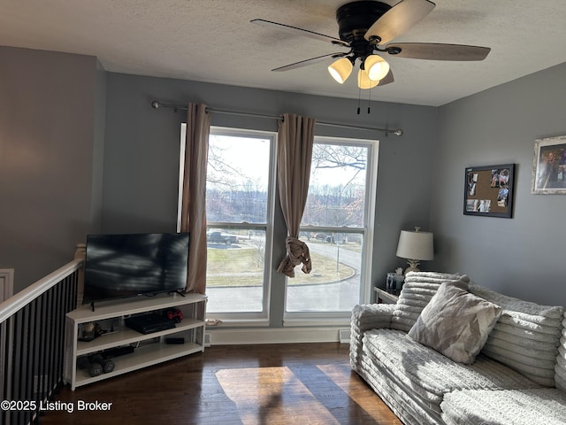 living area featuring a ceiling fan, wood finished floors, and a textured ceiling