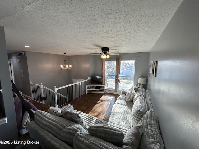 living area with visible vents, a notable chandelier, wood finished floors, and a textured ceiling