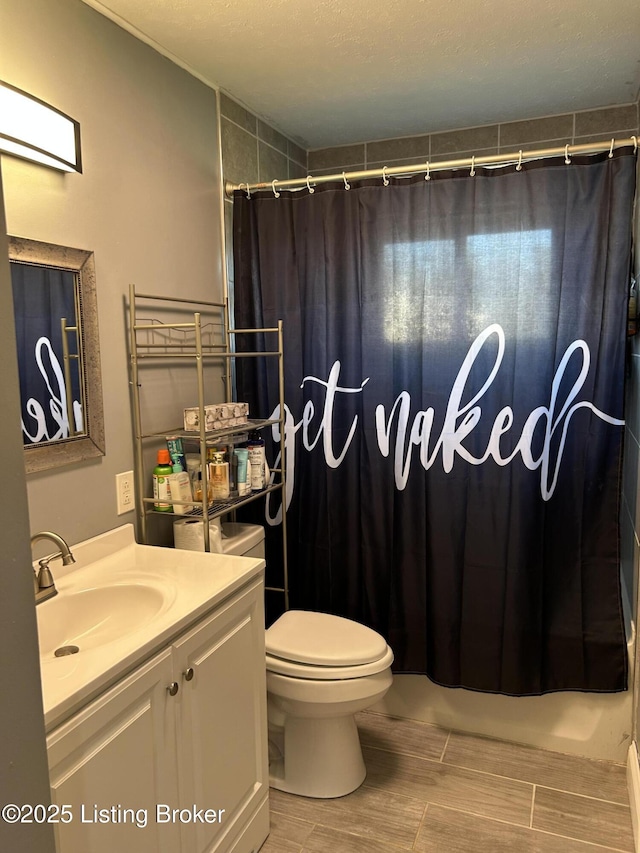 bathroom with toilet, vanity, and shower / bathtub combination with curtain