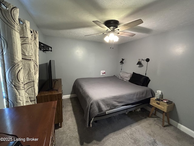 carpeted bedroom featuring a ceiling fan, baseboards, and a textured ceiling