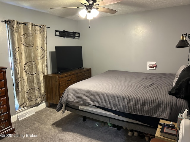 carpeted bedroom with visible vents, a textured ceiling, and ceiling fan