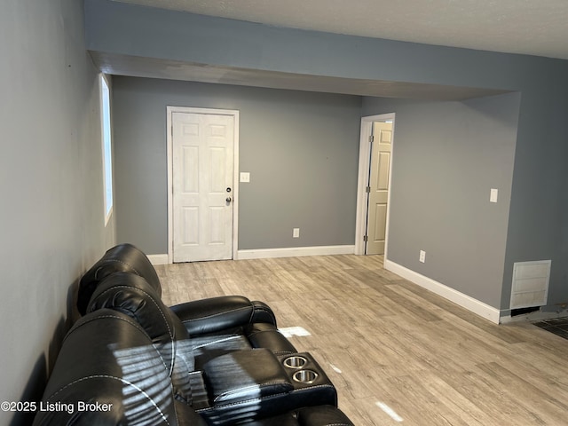 living room featuring light wood finished floors, visible vents, and baseboards