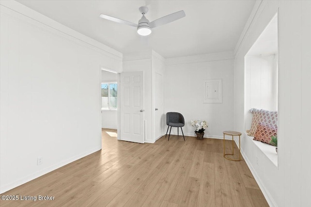 unfurnished room featuring light wood-style flooring, baseboards, a ceiling fan, and ornamental molding