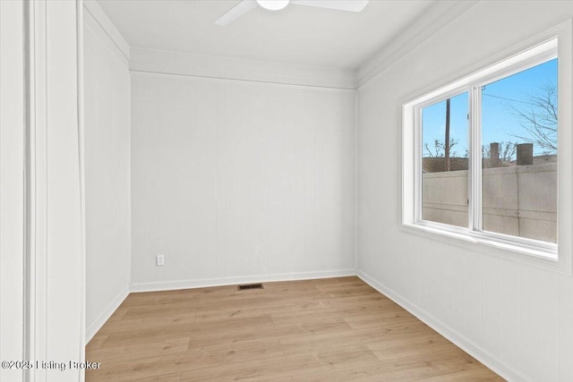 unfurnished room with visible vents, a ceiling fan, light wood-type flooring, and baseboards