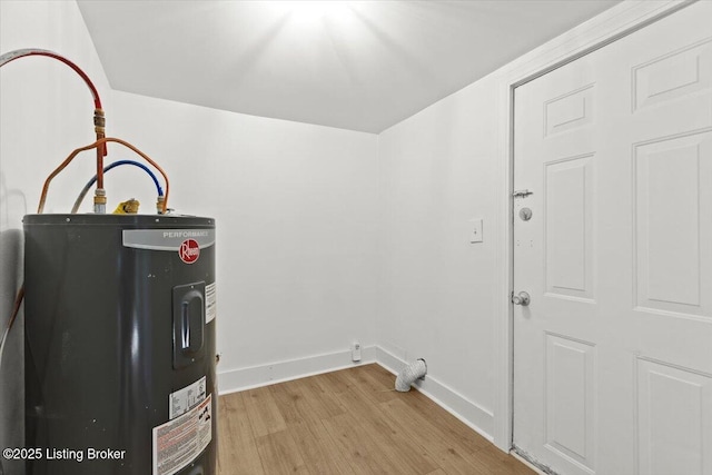 interior space with electric water heater, light wood-type flooring, and baseboards