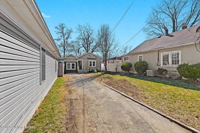 view of yard featuring central air condition unit, an outdoor structure, and fence