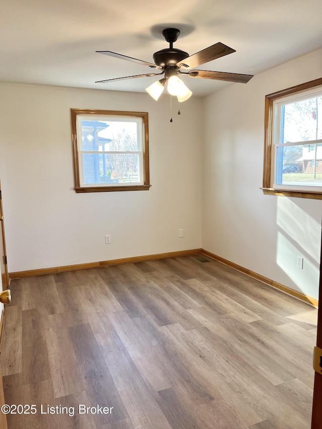 spare room with a ceiling fan, baseboards, and wood finished floors