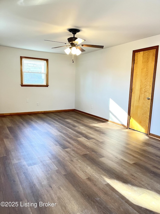 unfurnished room with dark wood finished floors, ceiling fan, and baseboards