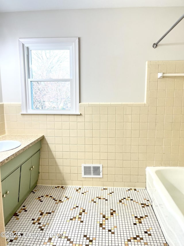 bathroom featuring visible vents, a shower, tile walls, a bath, and tile patterned floors