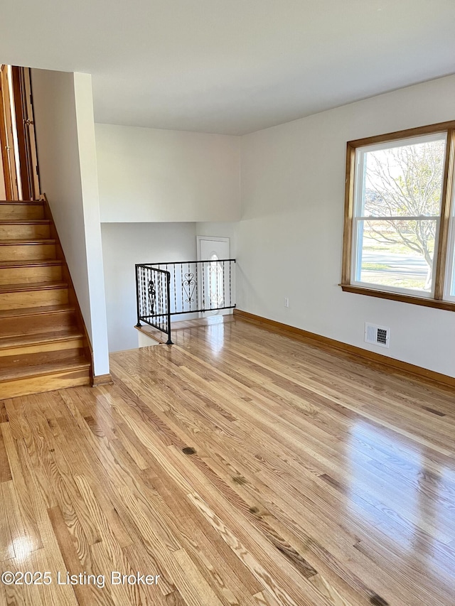 unfurnished room with baseboards, visible vents, and light wood finished floors