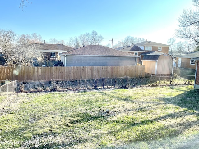 view of yard with a storage shed, an outdoor structure, and fence