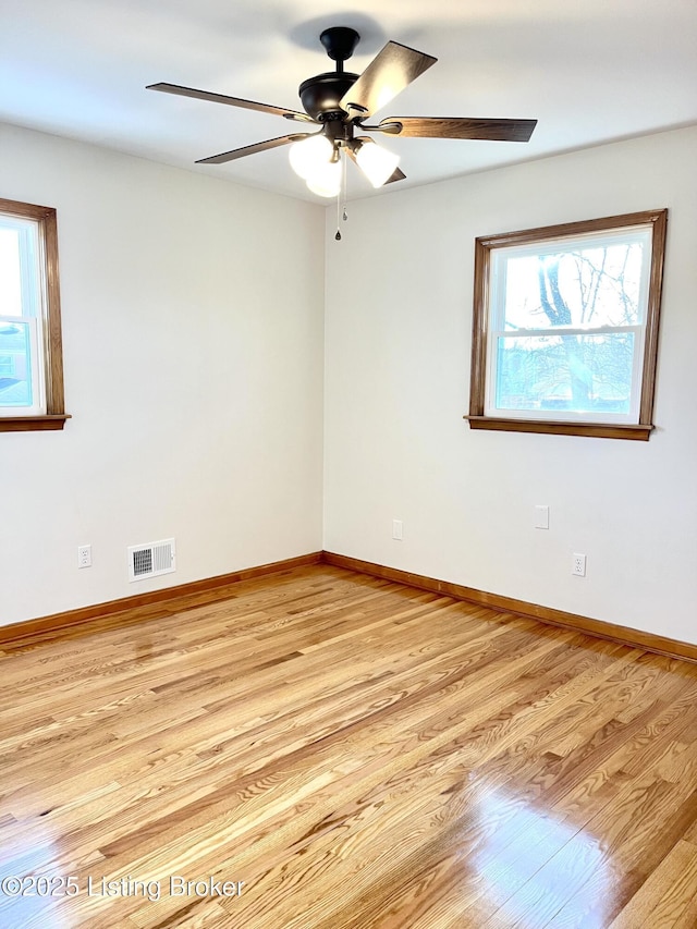 spare room featuring visible vents, light wood-style flooring, and baseboards