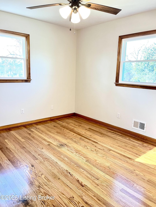 empty room with visible vents, baseboards, a ceiling fan, and light wood finished floors