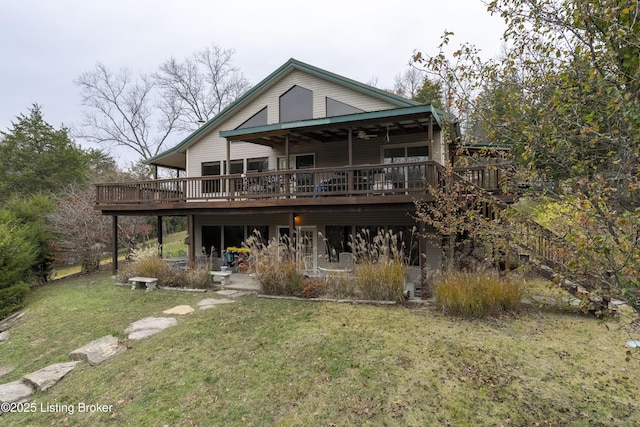 back of property featuring a lawn, a deck, and a patio area