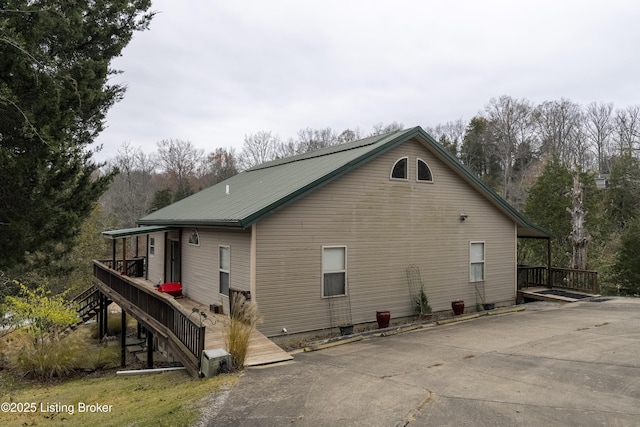 view of home's exterior with metal roof and stairs