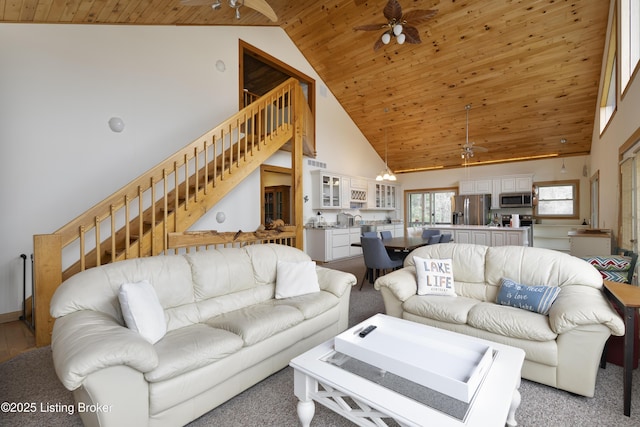 living room with stairway, high vaulted ceiling, ceiling fan, and wooden ceiling