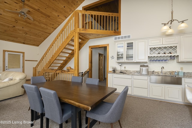 dining space with visible vents, light colored carpet, stairs, indoor wet bar, and wooden ceiling