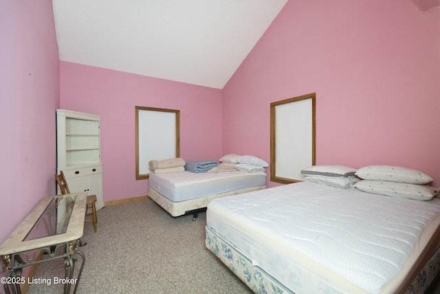 carpeted bedroom featuring lofted ceiling and baseboards