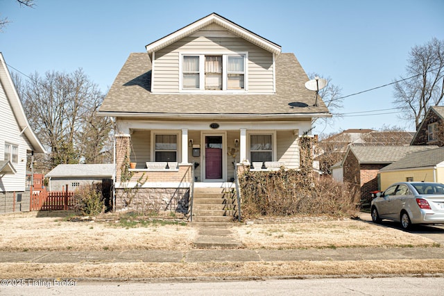 bungalow-style home with fence, a porch, and a shingled roof