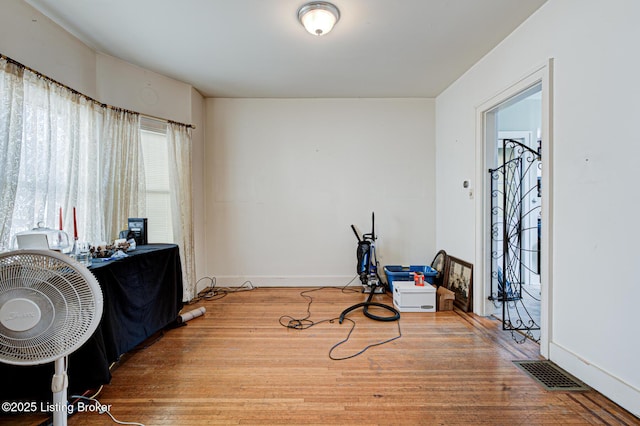 interior space with wood finished floors, visible vents, and baseboards