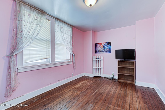 unfurnished living room with baseboards and wood-type flooring