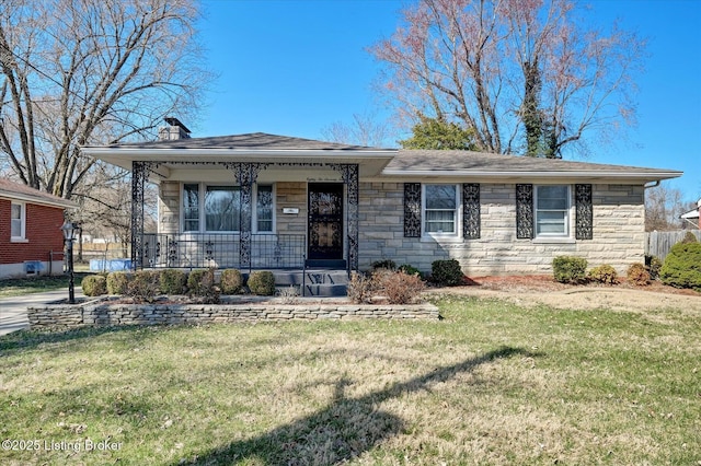 view of front of property with a front yard, a porch, stone siding, and a chimney