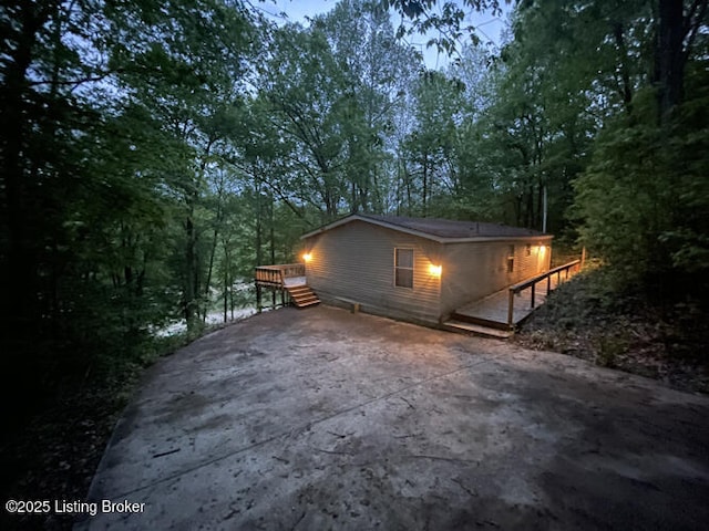 view of property exterior with a deck and driveway