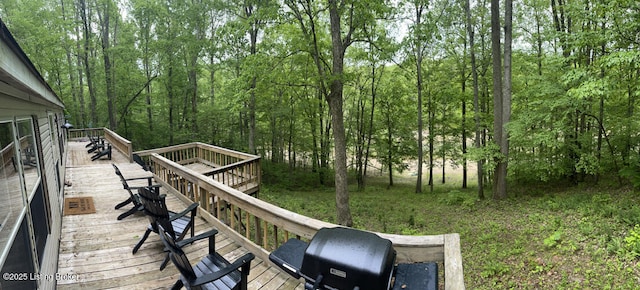 deck featuring area for grilling and a wooded view