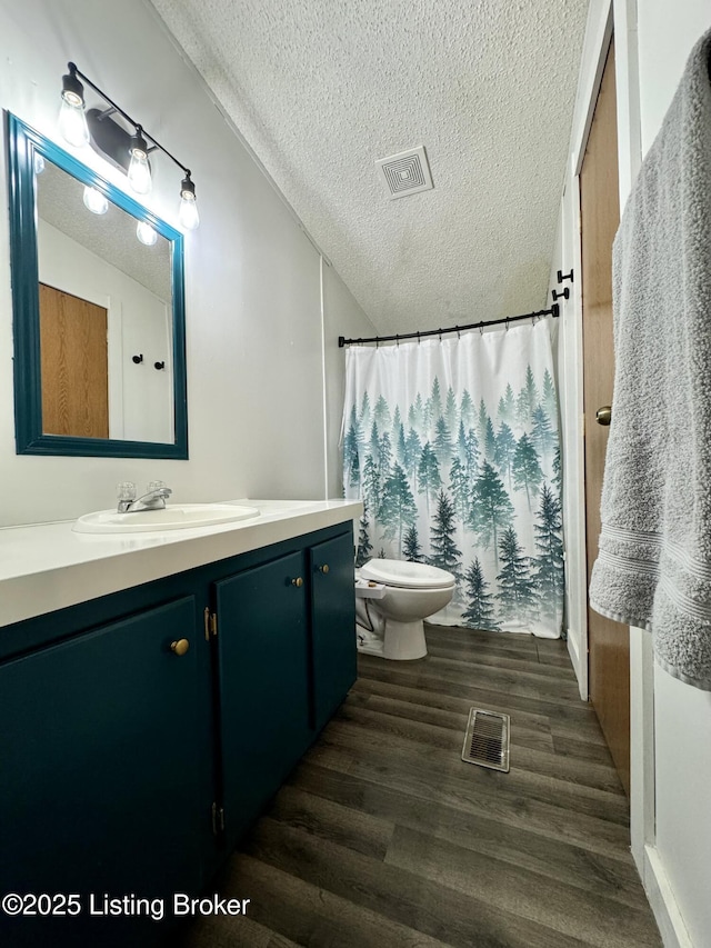 bathroom with vaulted ceiling, toilet, wood finished floors, and visible vents