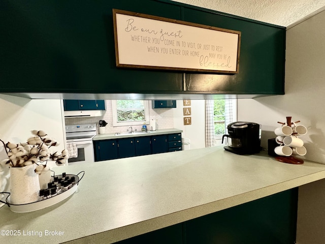 kitchen with white electric stove, blue cabinets, plenty of natural light, and a sink